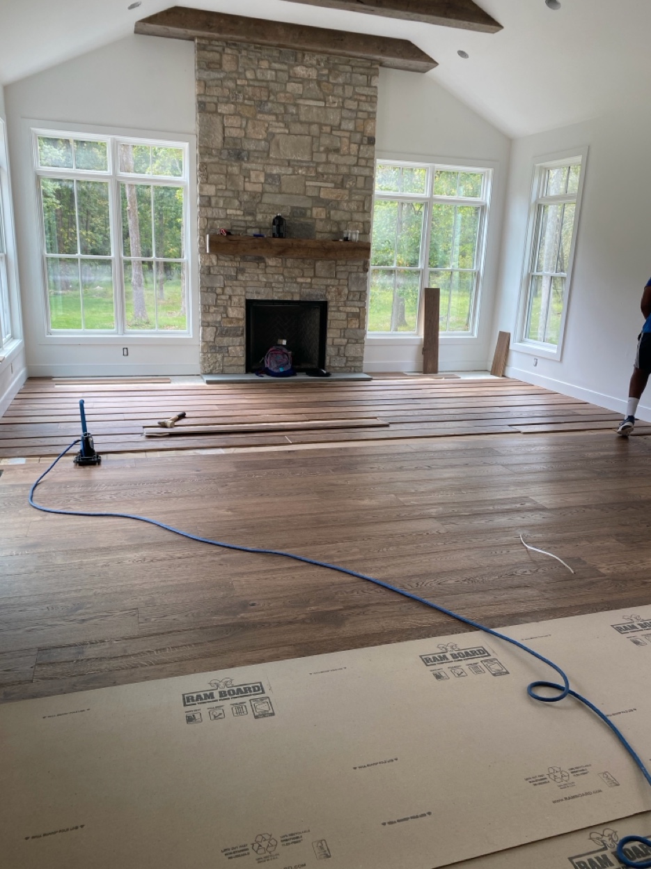 Engineered hardwood installation with stone fireplace by East Coast Floors